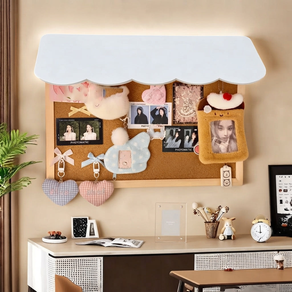 A wall-mounted cork bulletin board with a white awning-style top, styled in a home office setting. The board is decorated with plush toys, heart-shaped tags, and a cute character photo frame.